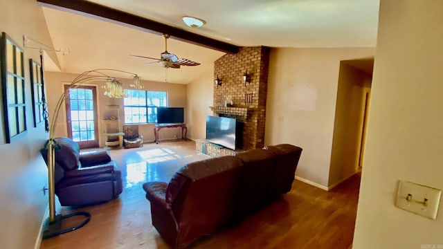 living room with vaulted ceiling with beams, ceiling fan, dark wood-type flooring, and a brick fireplace