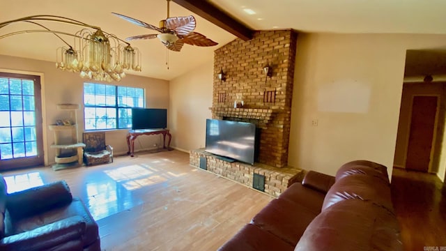 living room with ceiling fan with notable chandelier, wood-type flooring, and vaulted ceiling with beams