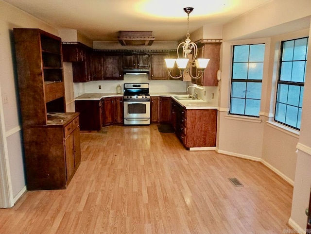 kitchen featuring a chandelier, light hardwood / wood-style flooring, hanging light fixtures, and stainless steel range with gas stovetop