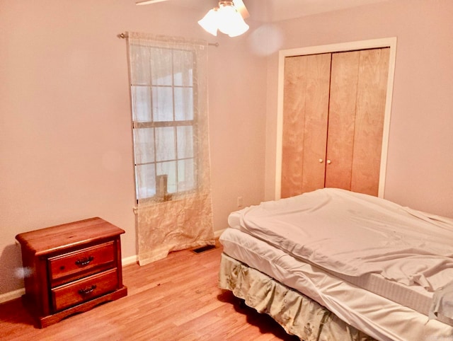 bedroom with ceiling fan, a closet, and light hardwood / wood-style floors