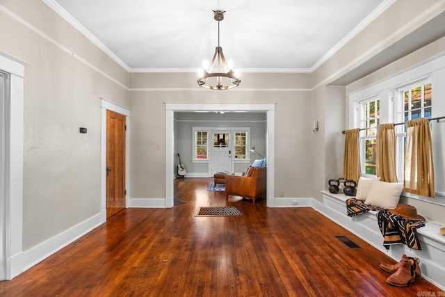 interior space with a notable chandelier, ornamental molding, and dark wood-type flooring