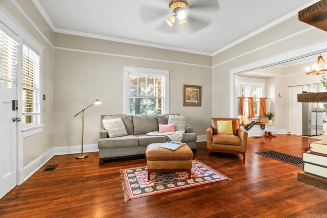 living room featuring ornamental molding, ceiling fan with notable chandelier, and hardwood / wood-style flooring