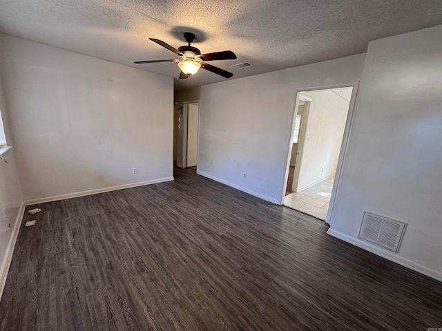 unfurnished room with a textured ceiling, dark hardwood / wood-style floors, and ceiling fan