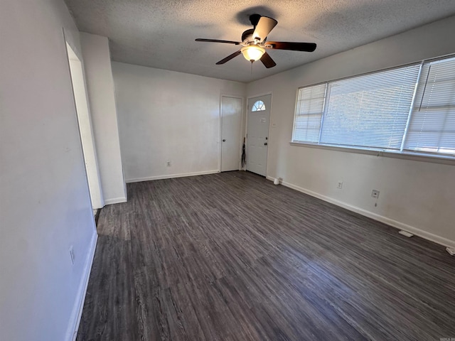 spare room featuring dark hardwood / wood-style floors, ceiling fan, and a textured ceiling