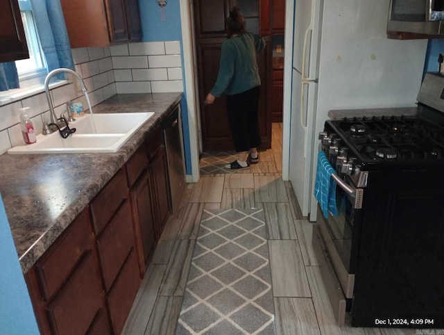 kitchen with decorative backsplash, sink, and appliances with stainless steel finishes