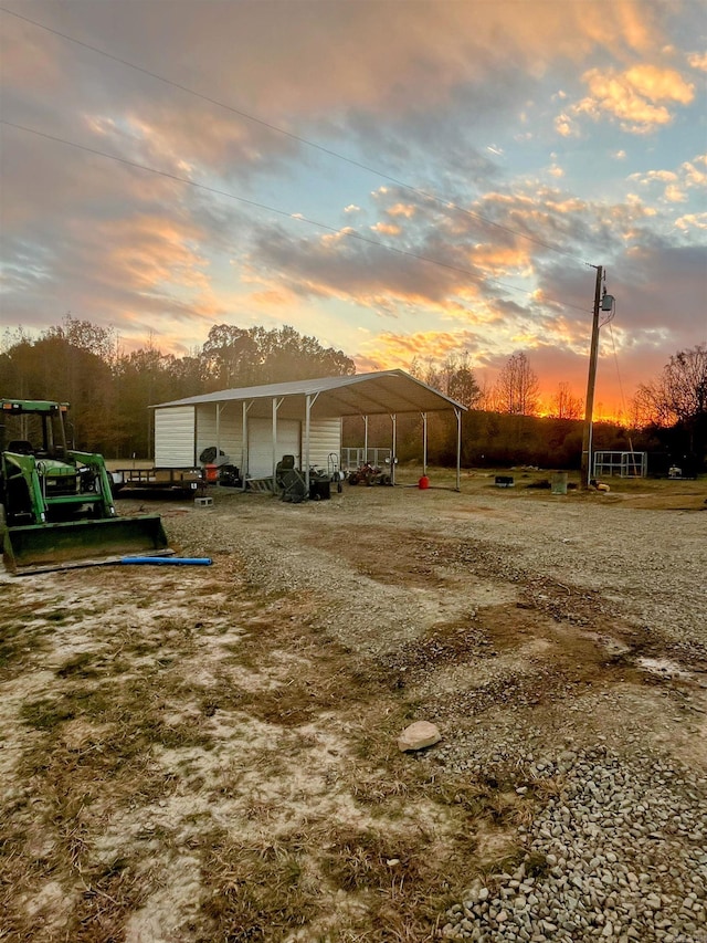 yard at dusk featuring a carport