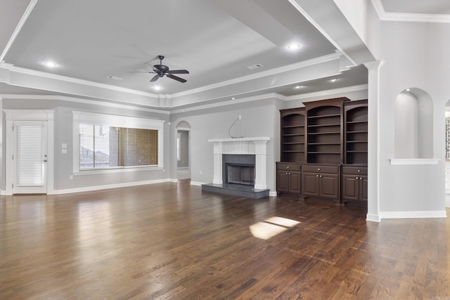 unfurnished living room with a fireplace, ornamental molding, ceiling fan, and dark wood-type flooring