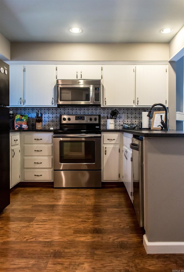 kitchen with white cabinets, decorative backsplash, stainless steel appliances, and dark hardwood / wood-style floors