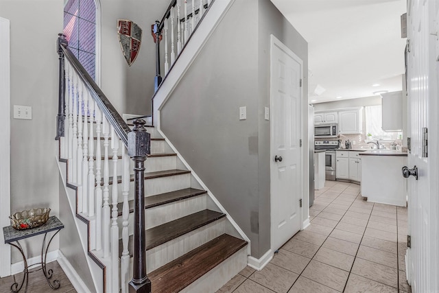 stairway with tile patterned flooring and sink