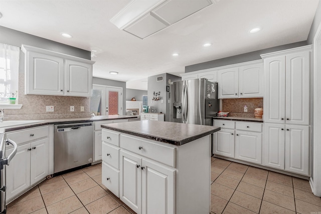 kitchen with appliances with stainless steel finishes, a center island, and white cabinetry