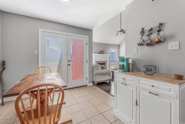 kitchen with white cabinets, ceiling fan, light tile patterned flooring, and lofted ceiling