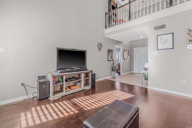 living room featuring light hardwood / wood-style flooring and a high ceiling