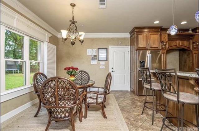 dining area with an inviting chandelier, a wealth of natural light, and ornamental molding