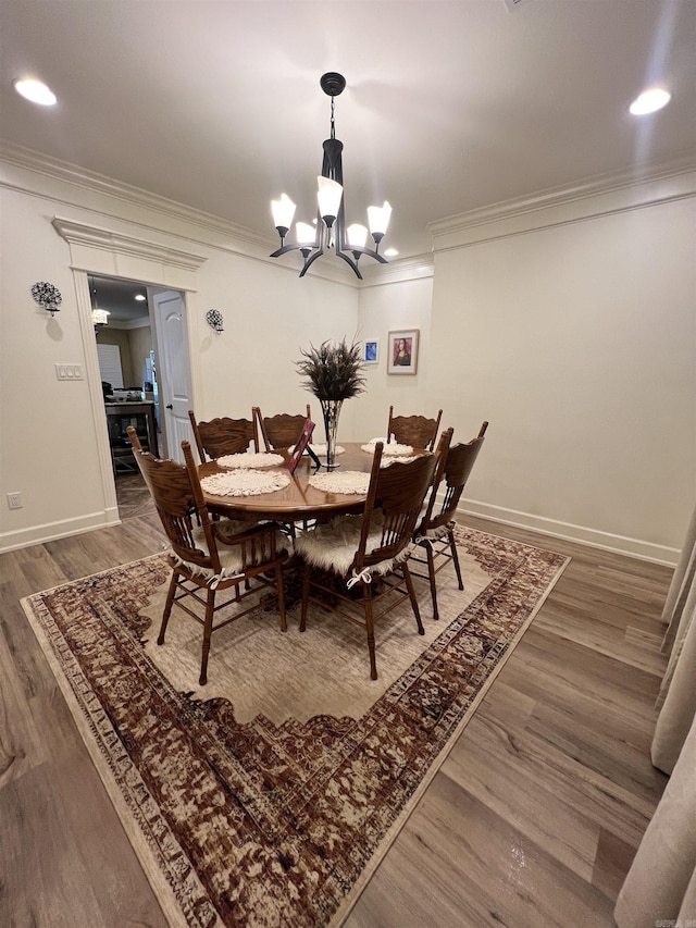 dining room with dark hardwood / wood-style floors, crown molding, and an inviting chandelier