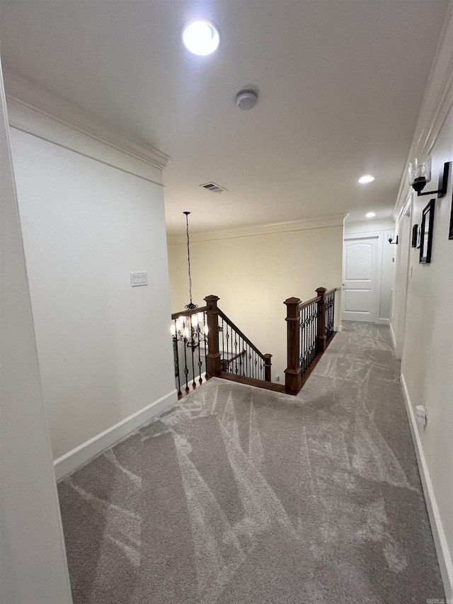 staircase with carpet, a chandelier, and ornamental molding