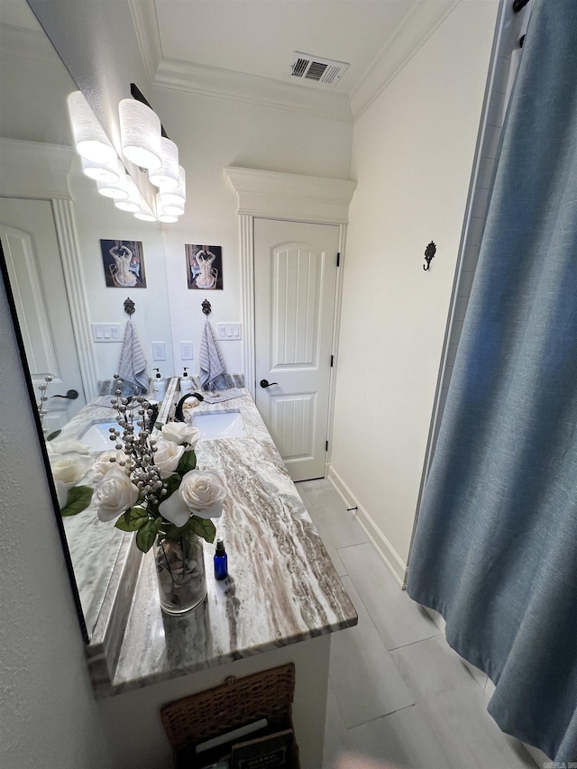 bathroom with tile patterned floors, vanity, an inviting chandelier, and ornamental molding