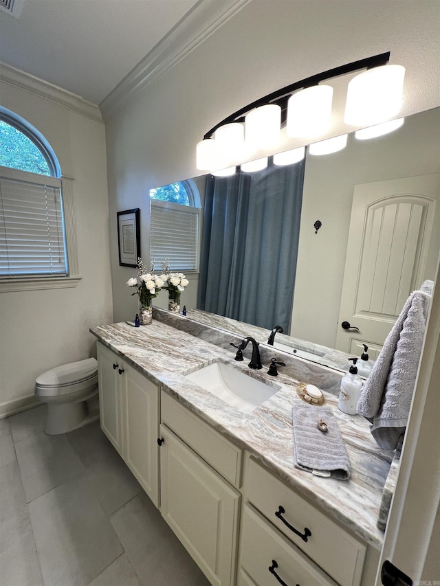 bathroom with tile patterned floors, vanity, toilet, and crown molding