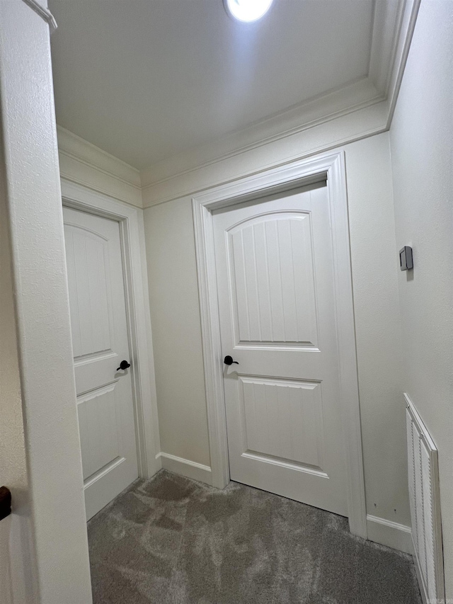 hall featuring dark colored carpet and crown molding