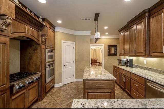 kitchen featuring appliances with stainless steel finishes, a center island, light stone counters, and hanging light fixtures