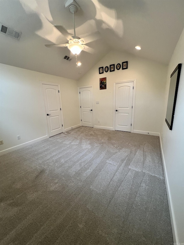 carpeted empty room featuring ceiling fan and vaulted ceiling