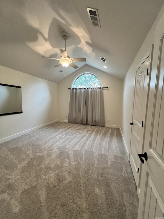 empty room featuring carpet floors, ceiling fan, and lofted ceiling