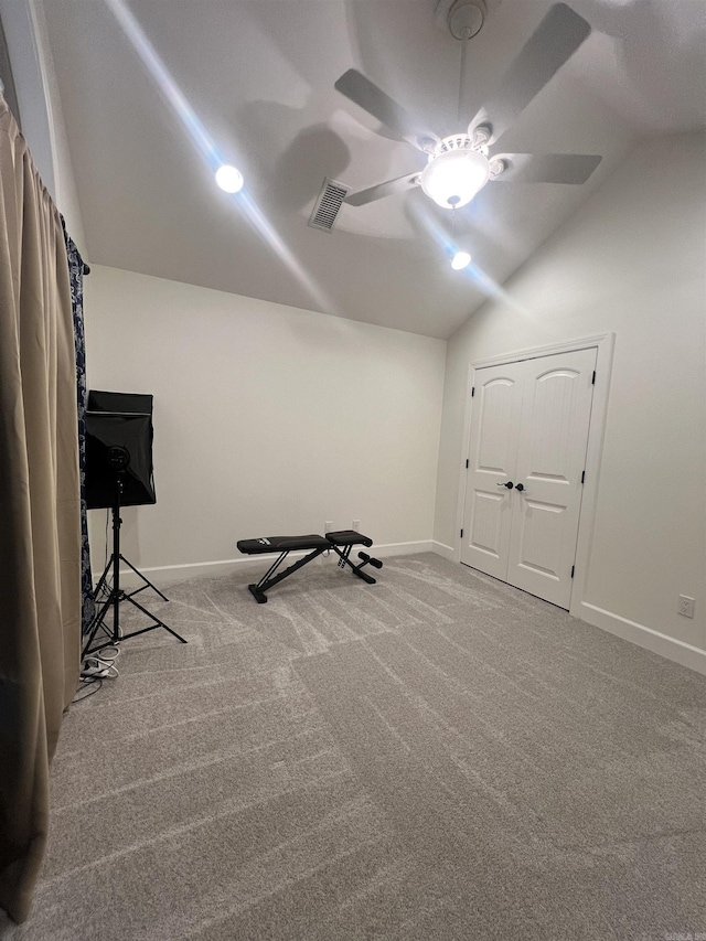 workout room featuring ceiling fan, carpet, and vaulted ceiling