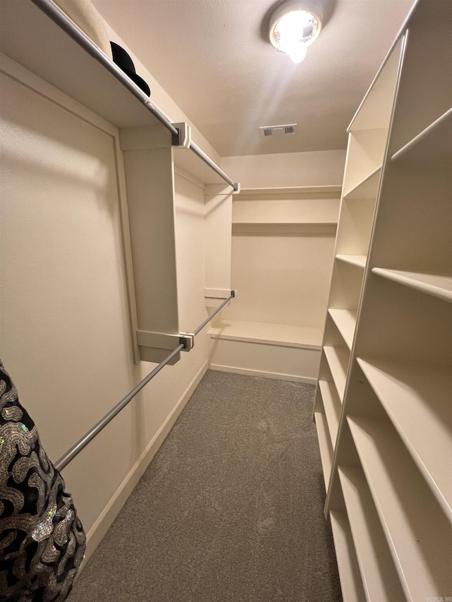 spacious closet featuring dark colored carpet