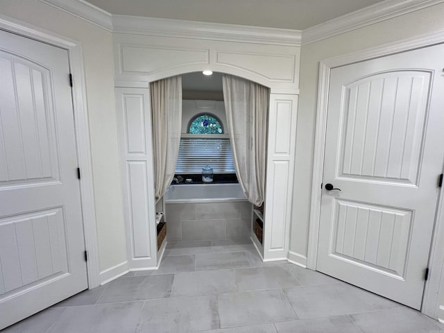 hall with light tile patterned floors and crown molding