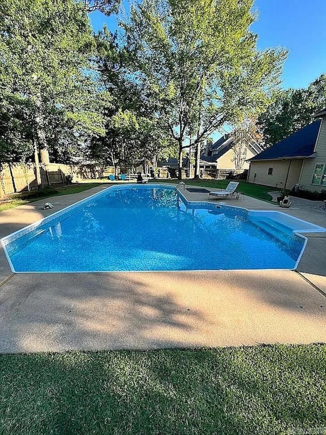 view of swimming pool with a patio and a diving board