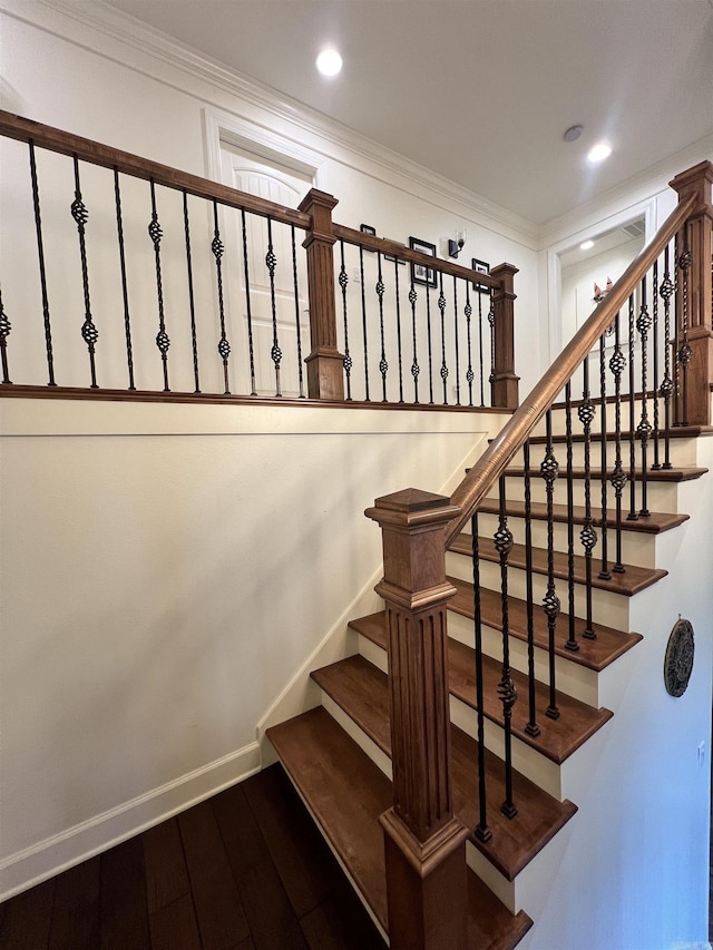 stairs with wood-type flooring and ornamental molding