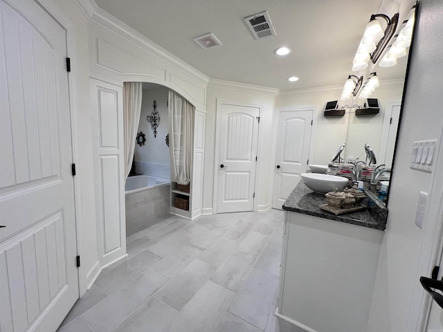 bathroom with vanity and tiled tub