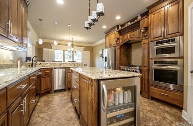 kitchen featuring stainless steel appliances, beverage cooler, light stone counters, decorative light fixtures, and a kitchen island