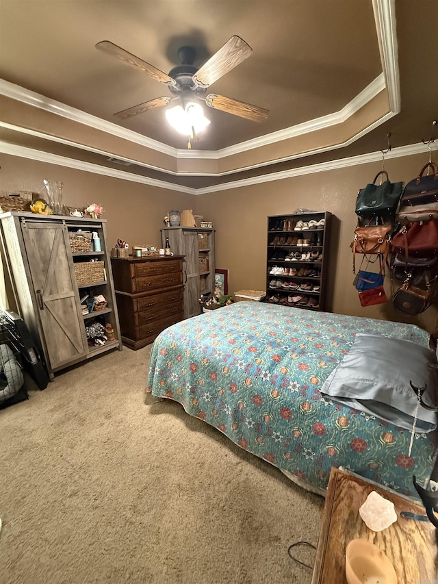 bedroom with ceiling fan, a tray ceiling, carpet floors, and ornamental molding