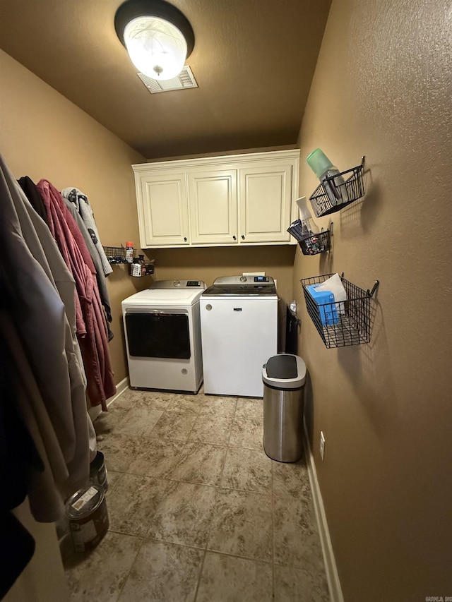 laundry room featuring washer and dryer, baseboards, and cabinet space