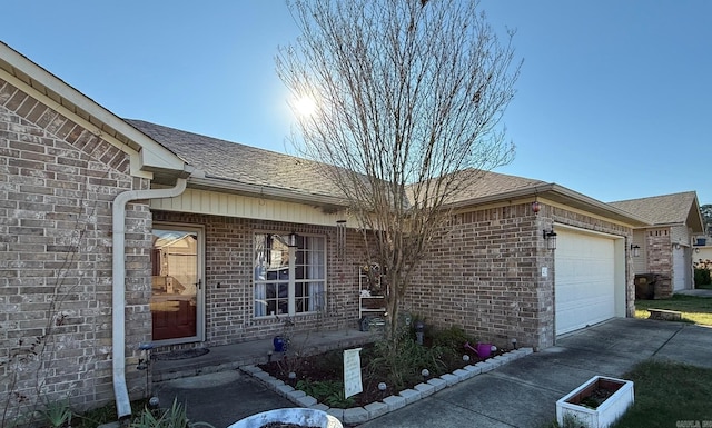 view of front of house with brick siding, concrete driveway, an attached garage, and a shingled roof