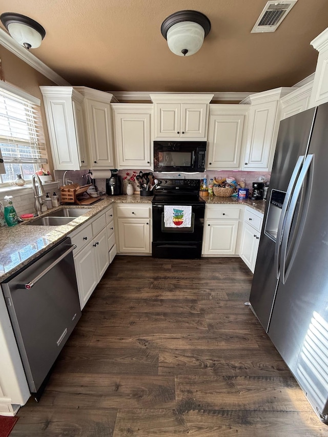 kitchen with visible vents, dark wood-style flooring, a sink, black appliances, and white cabinetry