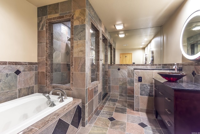 bathroom featuring vanity, tile walls, and independent shower and bath