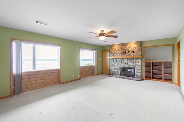 unfurnished living room featuring carpet, ceiling fan, and a fireplace