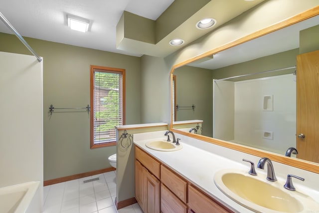 bathroom featuring tile patterned flooring, vanity, toilet, and a shower