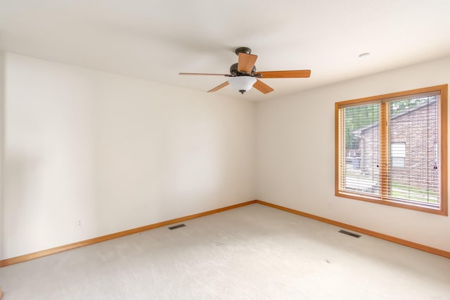 carpeted empty room with a wealth of natural light and ceiling fan