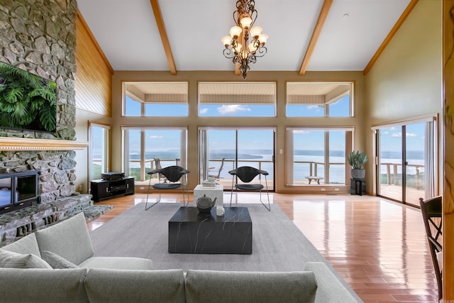 living room featuring plenty of natural light, beam ceiling, a water view, and high vaulted ceiling