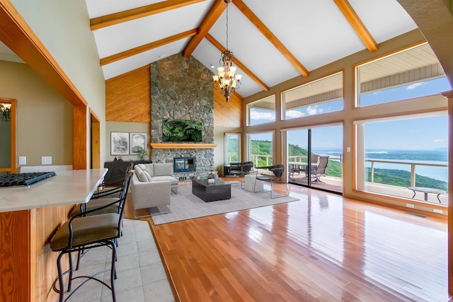 living room with a chandelier, a fireplace, high vaulted ceiling, and light hardwood / wood-style floors