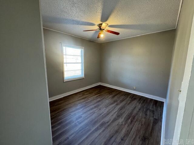 unfurnished room featuring crown molding, dark wood-type flooring, and a textured ceiling