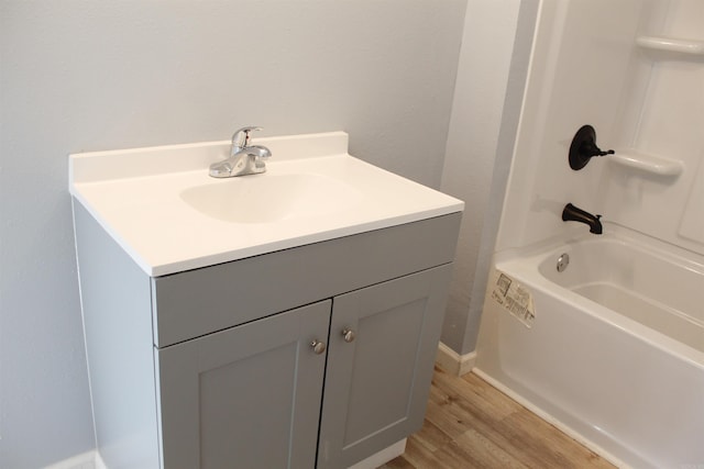 bathroom featuring hardwood / wood-style floors, vanity, and washtub / shower combination