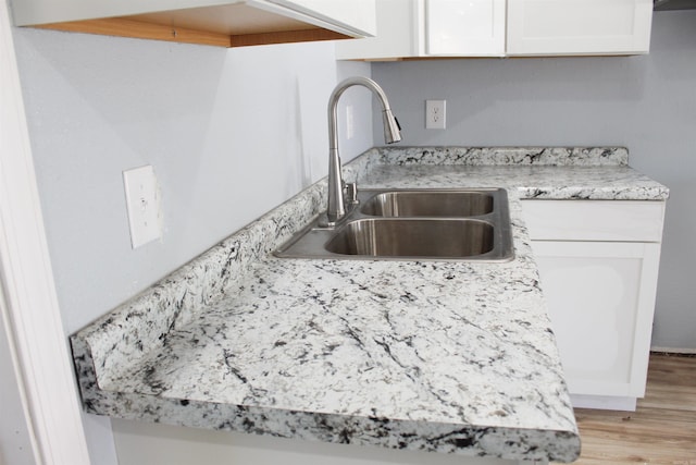 kitchen featuring sink, white cabinets, and light hardwood / wood-style floors