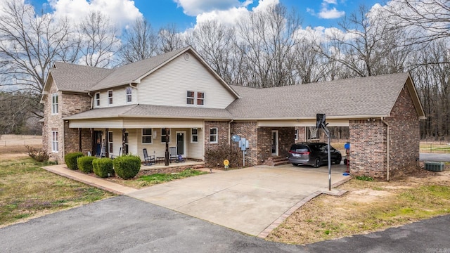 view of front of home with cooling unit, covered porch, and a carport