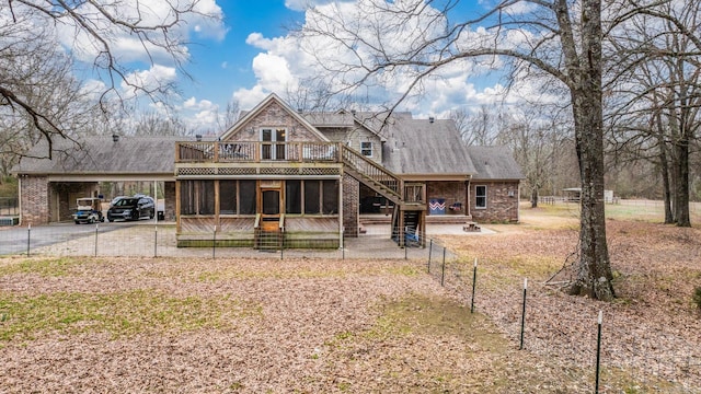 view of front of house with a sunroom, a deck, and a carport