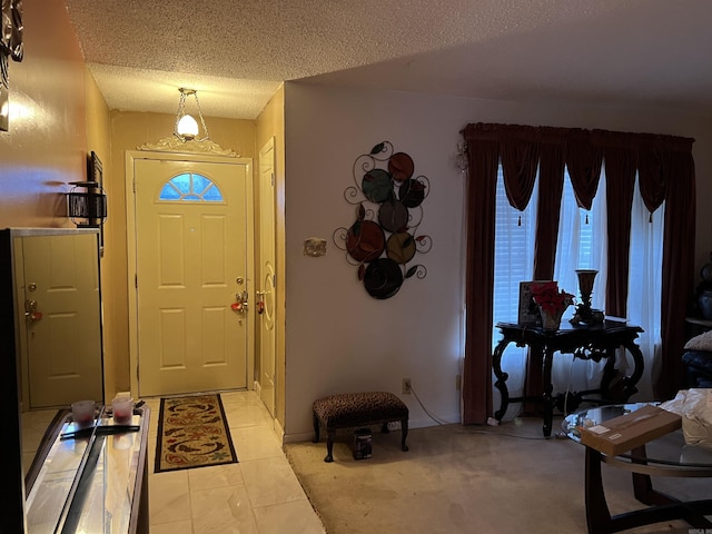 carpeted entryway with a textured ceiling