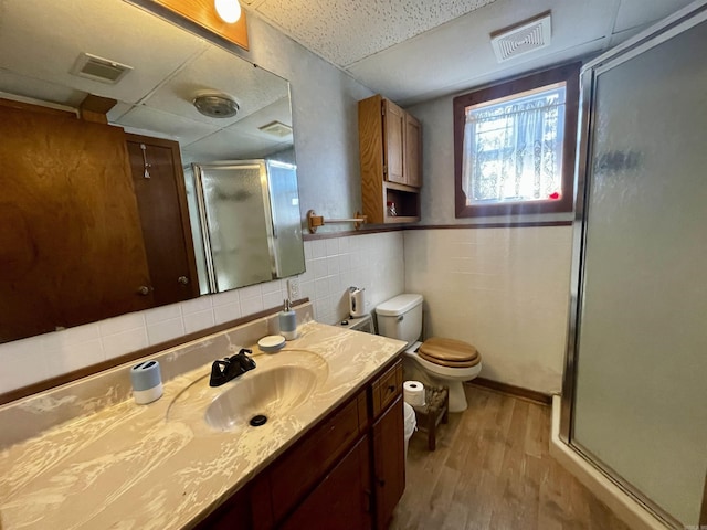 bathroom with tasteful backsplash, vanity, hardwood / wood-style floors, and walk in shower