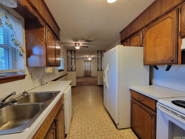 kitchen featuring a textured ceiling, ceiling fan, white appliances, and sink